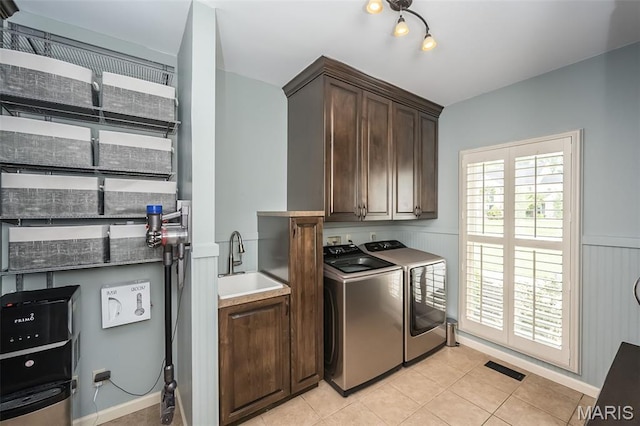 14703 Kulkarni Ct, Chesterfield, MO 63017 - laundry room featuring cabinet space, washing machine and clothes dryer, light tile patterned floors, and wainscoting