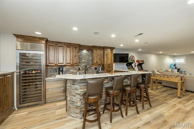 14703 Kulkarni Ct, Chesterfield, MO 63017 - indoor bar with wine cooler, light wood-style flooring, backsplash, and recessed lighting