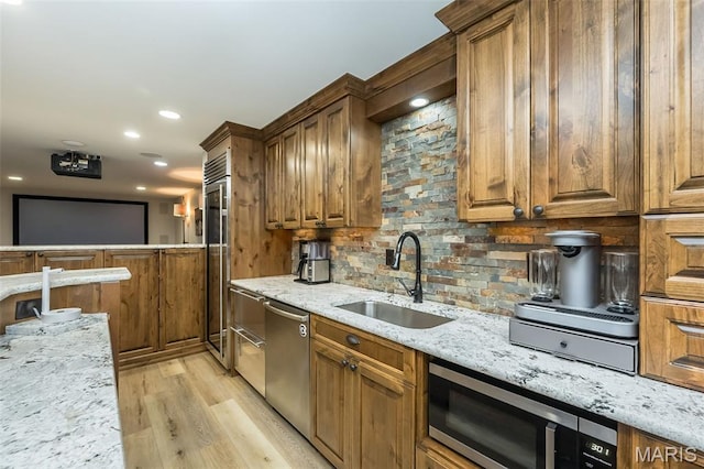 14703 Kulkarni Ct, Chesterfield, MO 63017 - kitchen with stainless steel appliances, tasteful backsplash, light stone countertops, light wood-style flooring, and brown cabinetry
