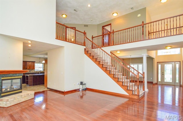 15 Fox Mill Dr, Maryville, IL 62062 - unfurnished living room with wood finished floors, stairs, a high ceiling, decorative columns, and recessed lighting