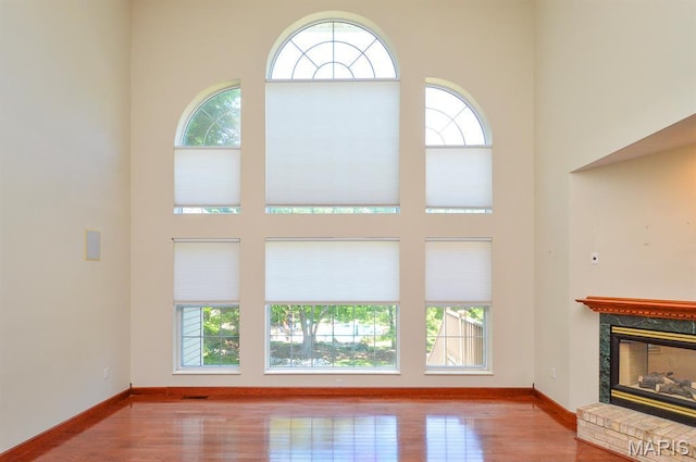 15 Fox Mill Dr, Maryville, IL 62062 - unfurnished living room featuring a high ceiling, wood finished floors, and a glass covered fireplace
