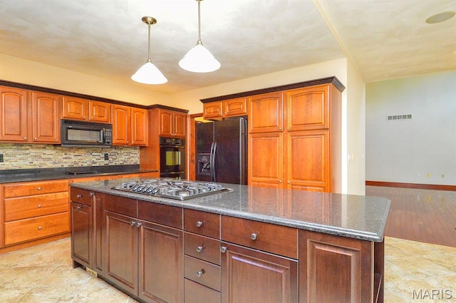 15 Fox Mill Dr, Maryville, IL 62062 - kitchen with black appliances, a kitchen island, tasteful backsplash, hanging light fixtures, and dark stone counters