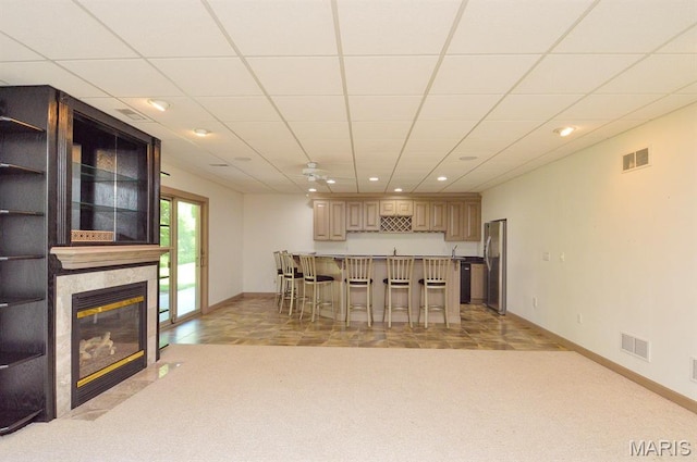 15 Fox Mill Dr, Maryville, IL 62062 - kitchen with a breakfast bar area, freestanding refrigerator, recessed lighting, a tiled fireplace, and a peninsula