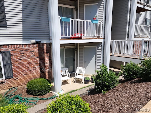 1239 Creve Coeur Crossing Ln Unit C, Chesterfield, MO 63017 - doorway to property featuring a balcony, brick siding, and covered porch