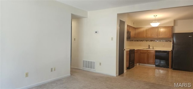 1239 Creve Coeur Crossing Ln Unit C, Chesterfield, MO 63017 - kitchen featuring black appliances, light countertops, tasteful backsplash, brown cabinets, and pendant lighting