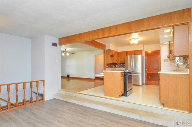 314 N 6th St, Mascoutah, IL 62258 - kitchen with freestanding refrigerator, light countertops, arched walkways, and light wood-style flooring