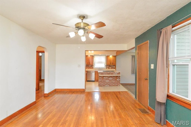 314 N 6th St, Mascoutah, IL 62258 - unfurnished living room with arched walkways, a ceiling fan, and light wood-style floors
