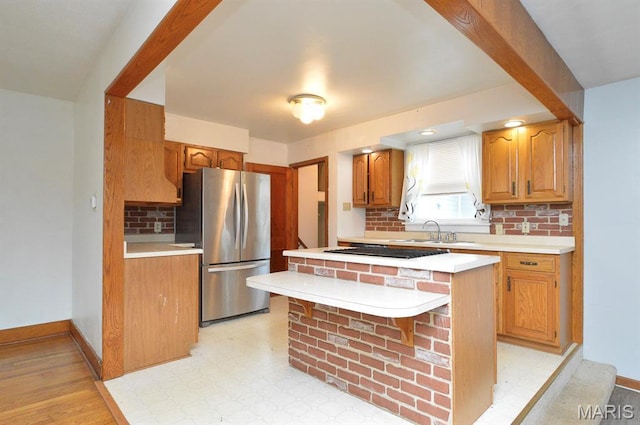 314 N 6th St, Mascoutah, IL 62258 - kitchen featuring freestanding refrigerator, light countertops, decorative backsplash, black electric cooktop, and a center island