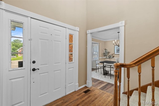 17 Beaujolais Dr, Florissant, MO 63031 - entryway featuring dark wood finished floors, a chandelier, ornamental molding, and stairway