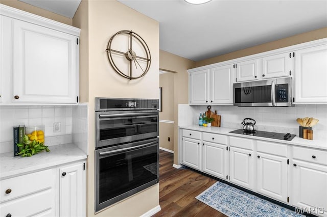17 Beaujolais Dr, Florissant, MO 63031 - kitchen featuring appliances with stainless steel finishes, tasteful backsplash, white cabinetry, and dark wood-style flooring