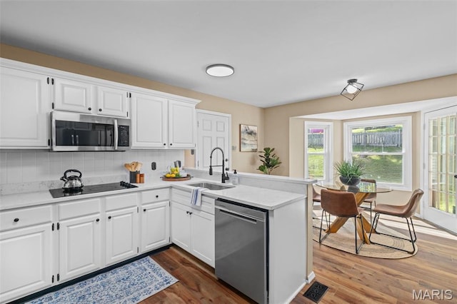 17 Beaujolais Dr, Florissant, MO 63031 - kitchen with appliances with stainless steel finishes, a peninsula, light countertops, and tasteful backsplash
