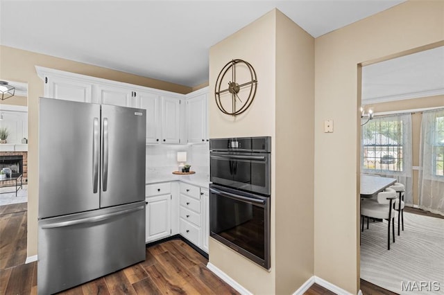 17 Beaujolais Dr, Florissant, MO 63031 - kitchen with freestanding refrigerator, dark wood-type flooring, white cabinets, and a chandelier
