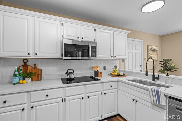 17 Beaujolais Dr, Florissant, MO 63031 - kitchen featuring appliances with stainless steel finishes, white cabinets, backsplash, and light stone countertops