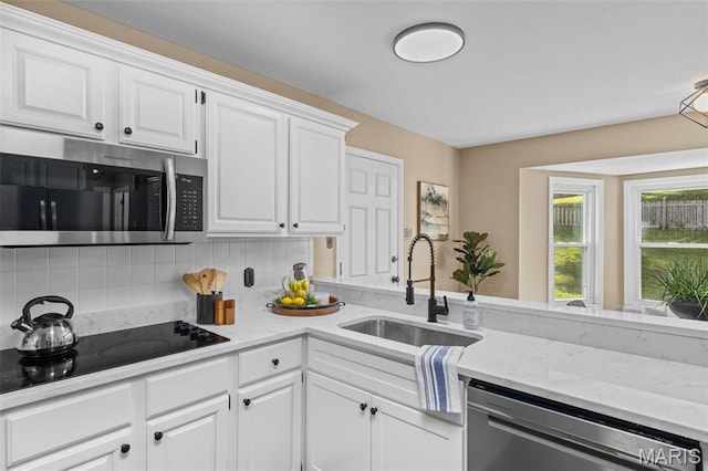 17 Beaujolais Dr, Florissant, MO 63031 - kitchen featuring stainless steel appliances, white cabinetry, tasteful backsplash, and light stone counters