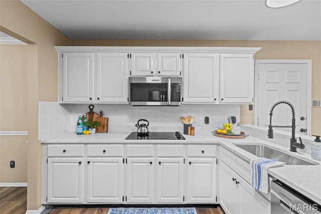 17 Beaujolais Dr, Florissant, MO 63031 - kitchen with appliances with stainless steel finishes, white cabinetry, dark wood-style floors, and tasteful backsplash