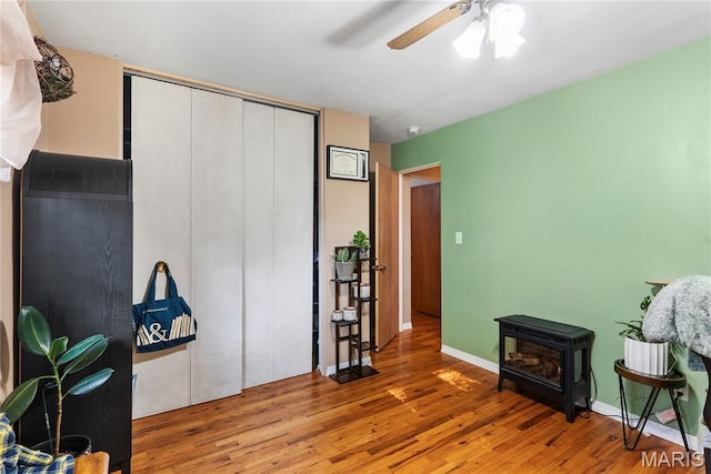 432 N 9th St, Mascoutah, IL 62258 - sitting room featuring wood finished floors, ceiling fan, and a wood stove