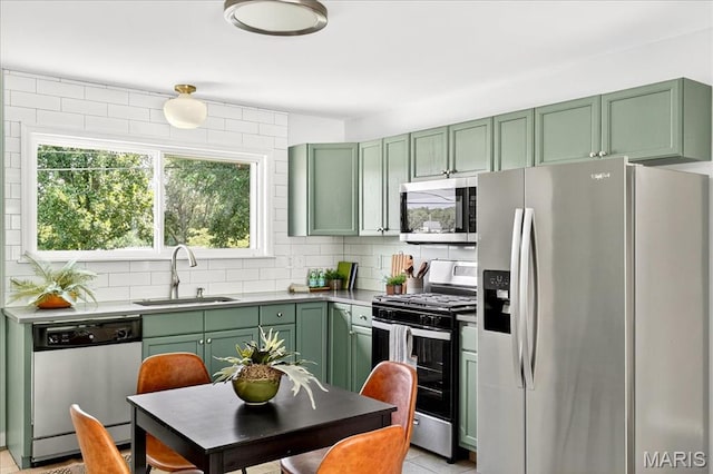 265 Francisca Dr, Florissant, MO 63031 - kitchen featuring stainless steel appliances, green cabinets, plenty of natural light, and tasteful backsplash