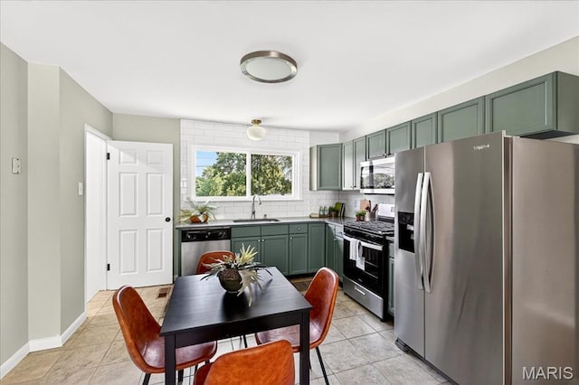 265 Francisca Dr, Florissant, MO 63031 - kitchen with stainless steel appliances, green cabinetry, tasteful backsplash, and light tile patterned flooring