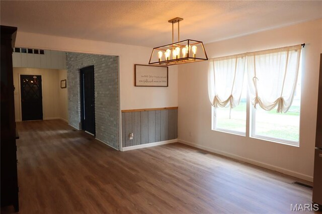 1001 E 2nd St, Saint Peter, IL 62880 - spare room with wood finished floors, a chandelier, wooden walls, wainscoting, and a fireplace