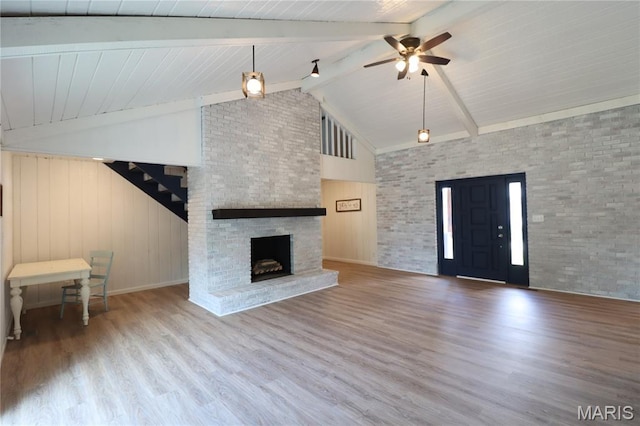 1001 E 2nd St, Saint Peter, IL 62880 - unfurnished living room with ceiling fan, wood finished floors, beamed ceiling, high vaulted ceiling, and a brick fireplace