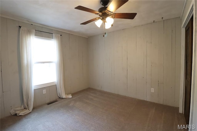 1001 E 2nd St, Saint Peter, IL 62880 - spare room with light colored carpet, ceiling fan, and wooden walls
