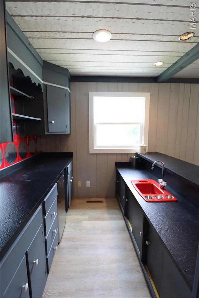 1001 E 2nd St, Saint Peter, IL 62880 - kitchen with dark countertops, light wood-type flooring, and stainless steel dishwasher