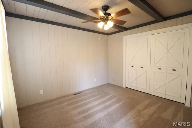 1001 E 2nd St, Saint Peter, IL 62880 - unfurnished bedroom featuring beam ceiling, carpet, wooden walls, and ceiling fan