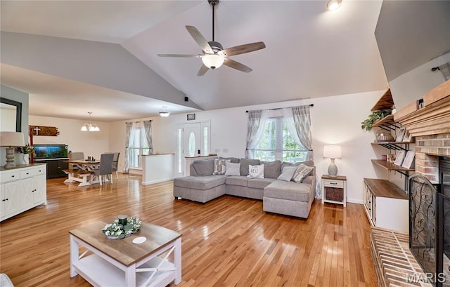 1939 N Rock Church Rd, Troy, MO 63379 - living room with light wood-style floors, vaulted ceiling, a ceiling fan, a chandelier, and a brick fireplace