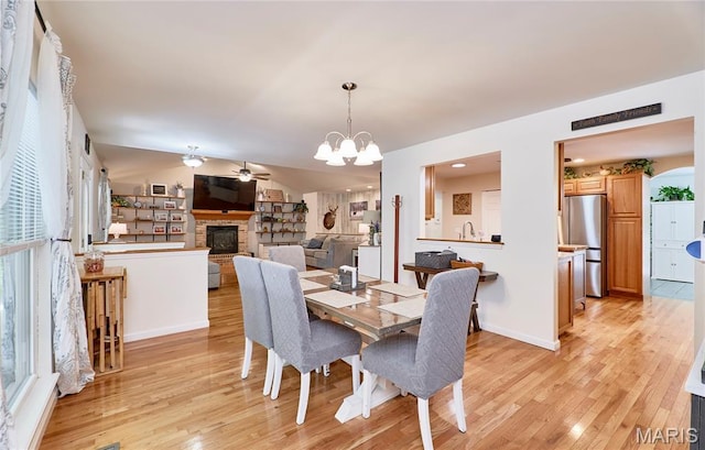 1939 N Rock Church Rd, Troy, MO 63379 - dining space with light wood-style floors, ceiling fan, a fireplace with raised hearth, and a chandelier