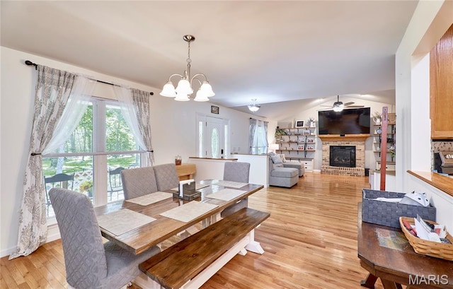 1939 N Rock Church Rd, Troy, MO 63379 - dining room featuring light wood-style floors, ceiling fan, a fireplace, a chandelier, and lofted ceiling