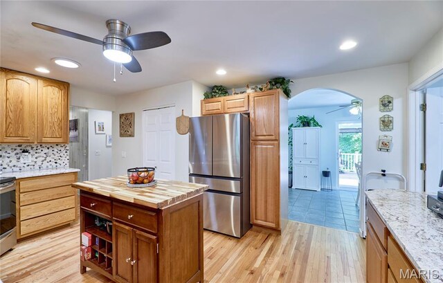 1939 N Rock Church Rd, Troy, MO 63379 - kitchen featuring appliances with stainless steel finishes, ceiling fan, wood counters, arched walkways, and light wood-style floors