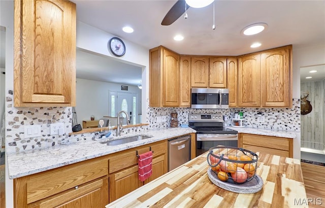 1939 N Rock Church Rd, Troy, MO 63379 - kitchen with stainless steel appliances, ceiling fan, backsplash, light stone counters, and recessed lighting