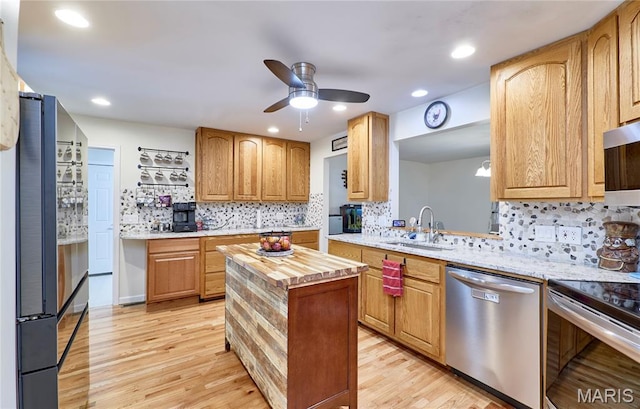 1939 N Rock Church Rd, Troy, MO 63379 - kitchen featuring appliances with stainless steel finishes, butcher block counters, ceiling fan, light wood-style flooring, and backsplash