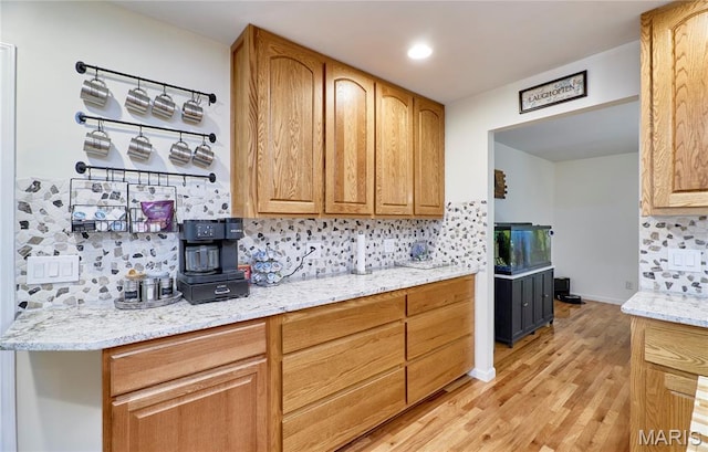 1939 N Rock Church Rd, Troy, MO 63379 - kitchen with backsplash, light wood-style flooring, and light stone countertops