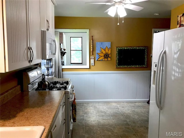103 Maupin Ave, New Haven, MO 63068 - kitchen featuring white appliances, ceiling fan, a wainscoted wall, and white cabinetry