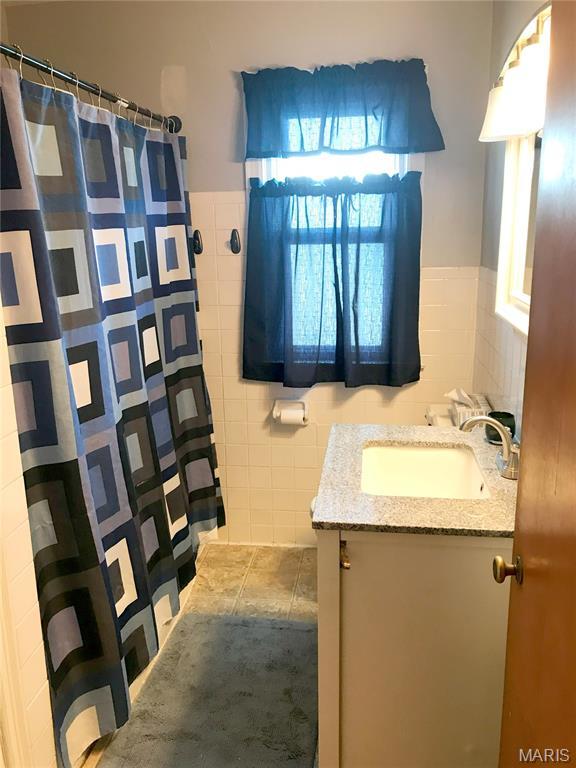 103 Maupin Ave, New Haven, MO 63068 - bathroom featuring tile walls, vanity, wainscoting, and curtained shower
