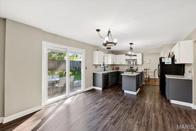 219 Royalltrail Ln, Saint Charles, MO 63368 - kitchen featuring a chandelier, appliances with stainless steel finishes, light countertops, a center island, and dark wood-type flooring