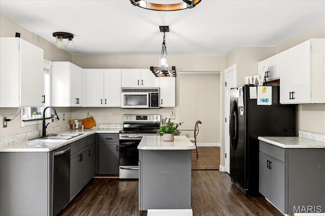219 Royalltrail Ln, Saint Charles, MO 63368 - kitchen featuring appliances with stainless steel finishes, gray cabinetry, light countertops, dark wood-style flooring, and a kitchen island