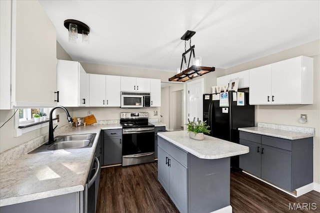 219 Royalltrail Ln, Saint Charles, MO 63368 - kitchen featuring stainless steel appliances, gray cabinets, dark wood-style flooring, a kitchen island, and light countertops