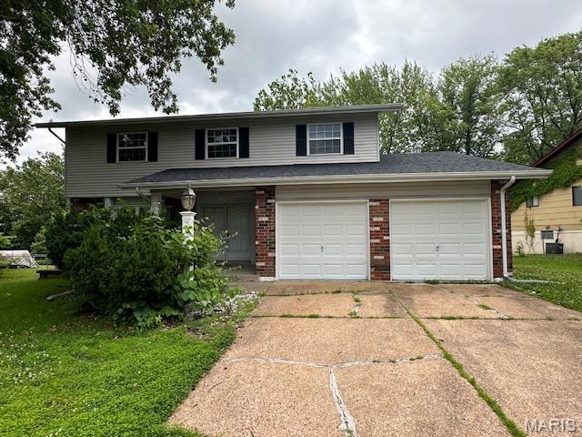 12750 Needle Point Ct, Florissant, MO 63033 - view of front of property with brick siding, concrete driveway, and a front lawn