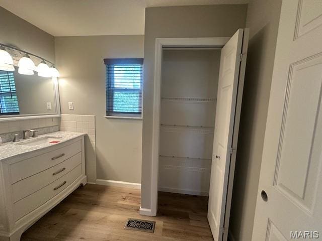 12750 Needle Point Ct, Florissant, MO 63033 - bathroom with vanity, wood finished floors, and decorative backsplash
