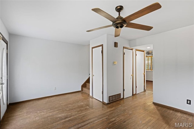 2239 University St, Saint Louis, MO 63107 - spare room featuring ceiling fan, hardwood / wood-style floors, and stairway