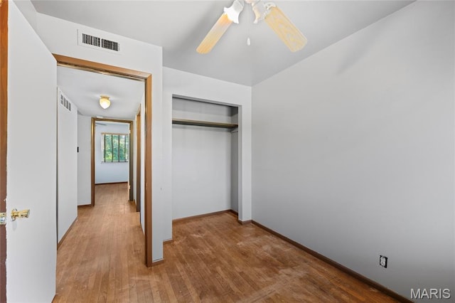 2239 University St, Saint Louis, MO 63107 - unfurnished bedroom with wood finished floors, a closet, and a ceiling fan