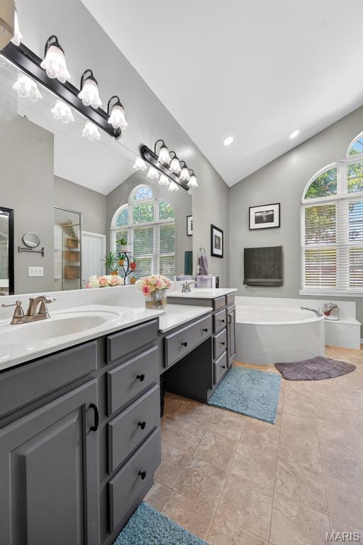 156 Bluffview Dr, Troy, MO 63379 - bathroom featuring vaulted ceiling, double vanity, healthy amount of natural light, a garden tub, and a chandelier