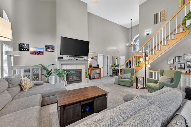 156 Bluffview Dr, Troy, MO 63379 - carpeted living room with a high ceiling, stairway, a tiled fireplace, and a chandelier