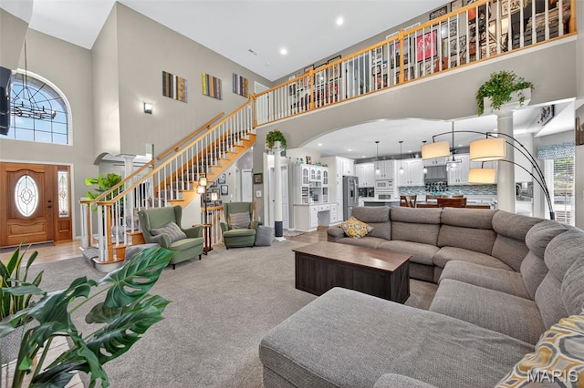 156 Bluffview Dr, Troy, MO 63379 - living area with a high ceiling, stairway, arched walkways, light colored carpet, and recessed lighting