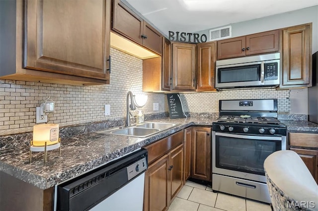 1326 Petite Dr, Saint Louis, MO 63138 - kitchen featuring stainless steel appliances, tasteful backsplash, and light tile patterned floors