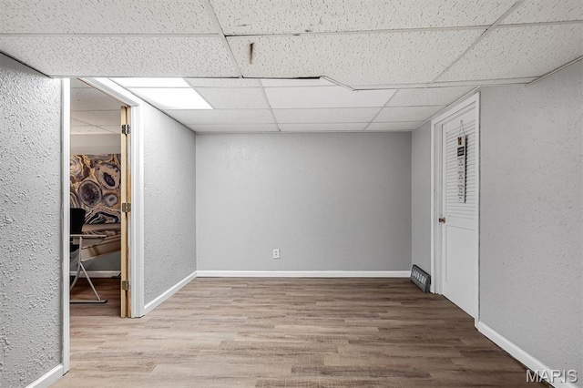 1326 Petite Dr, Saint Louis, MO 63138 - finished below grade area with a drop ceiling, wood finished floors, and a textured wall