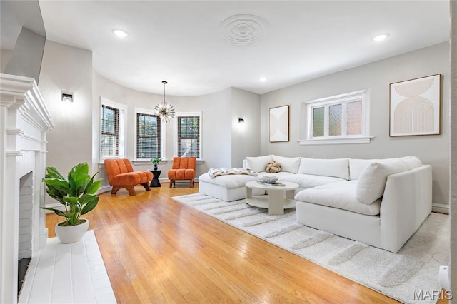7801 Delmar Blvd Unit 2W, University City, MO 63130 - living room featuring wood finished floors, a fireplace, a chandelier, and recessed lighting