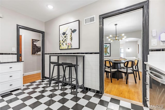 7801 Delmar Blvd Unit 2W, University City, MO 63130 - dining area featuring tile patterned floors, a chandelier, arched walkways, and recessed lighting